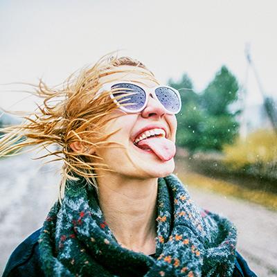  woman with glasses and tongue out under the rain