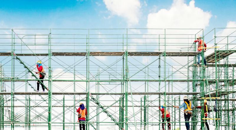 A group of construction workers on scaffolding in construction site. (1) A group of construction workers on scaffolding in construction site. (1)