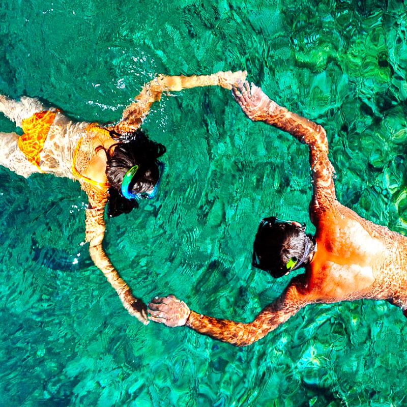 Two guys holding their hands in the sea