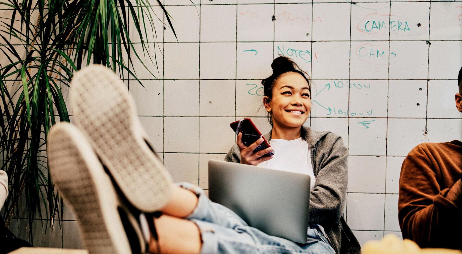 Large MS PPT Web Smiling young woman using mobile phone at work