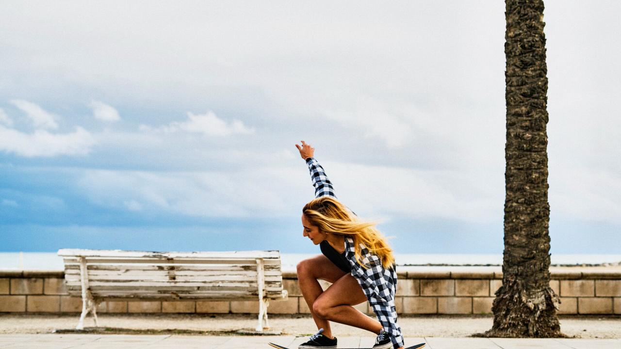 Large Web and Screen A young woman skateboards on the promenade Large Web and Screen A young woman skateboards on the promenade