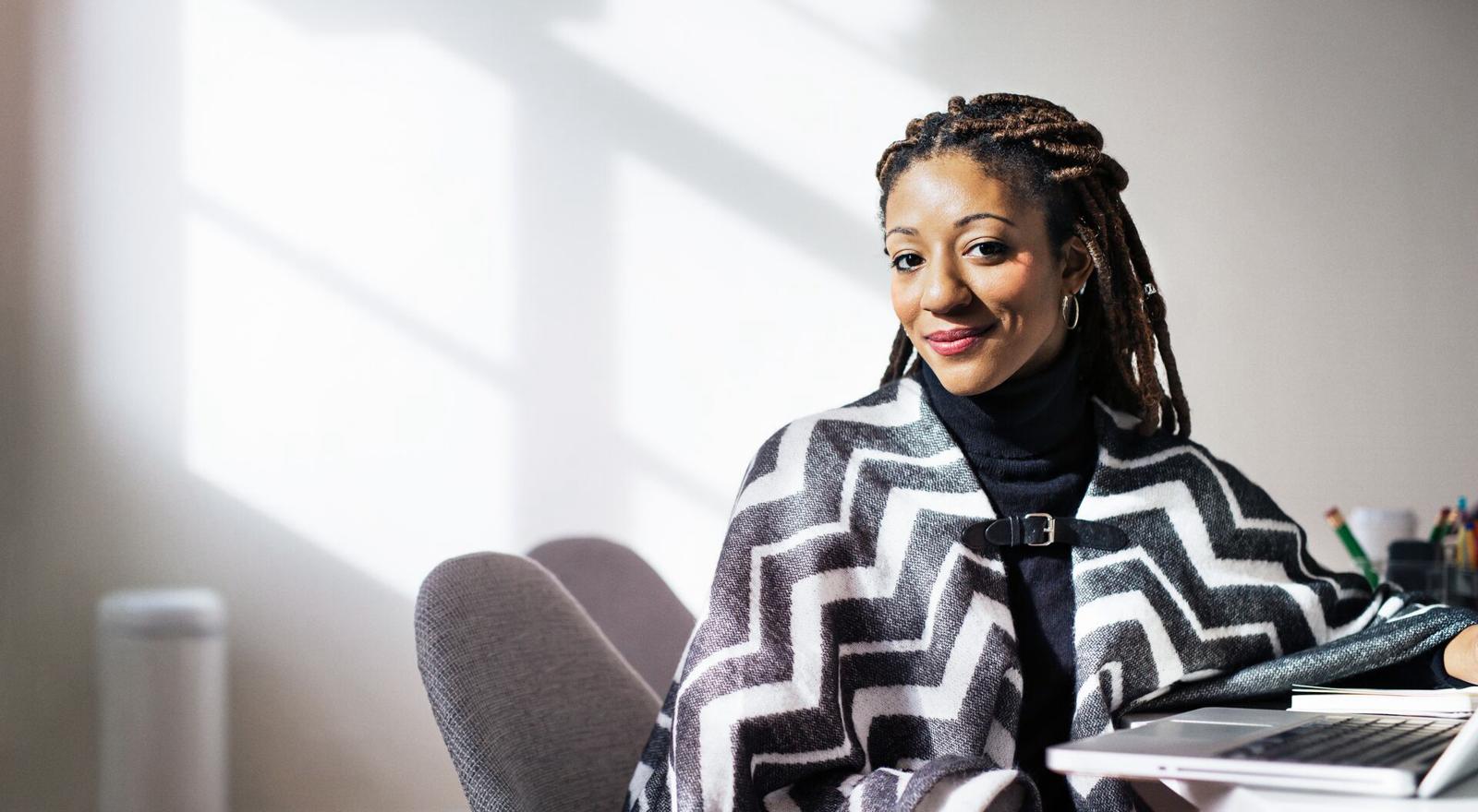 Large Web and Screen Smiling professional woman sat at a desk