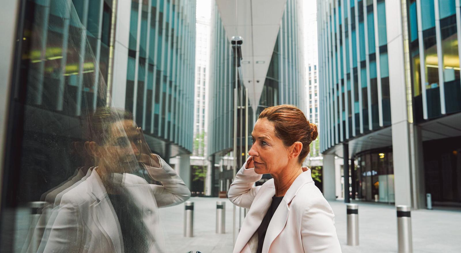 Large Web and Screen Woman checks her reflection before entering building