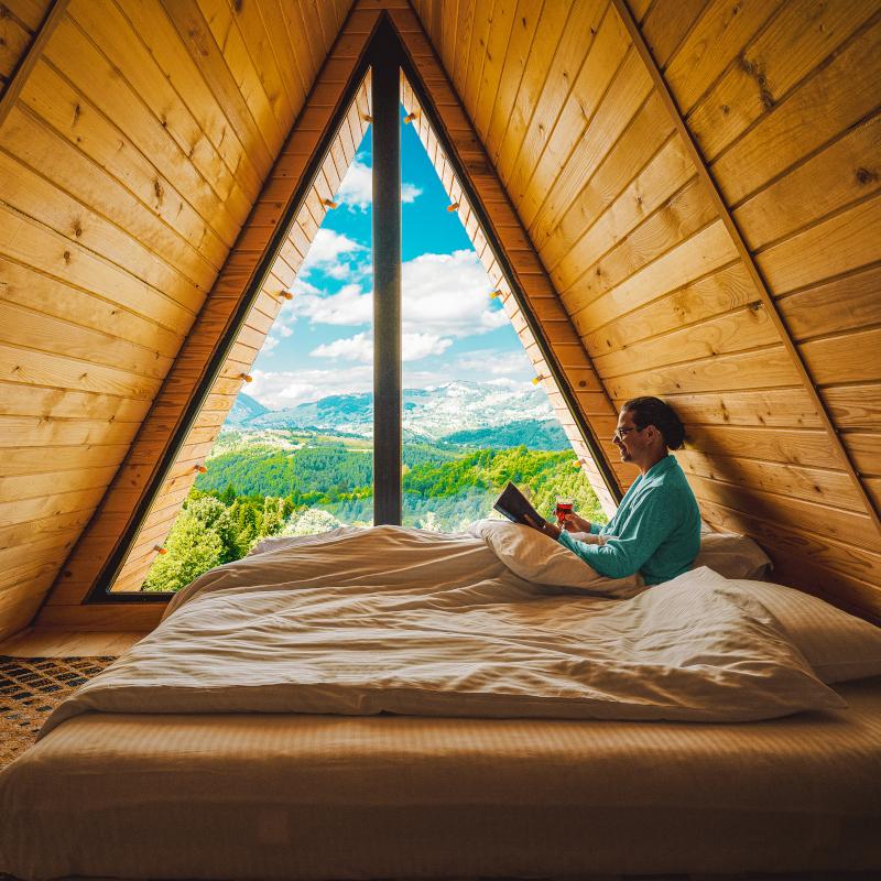 Man sitting on bed with nature view