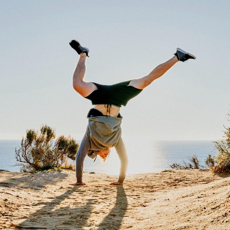Man standing on his hands in the dunes