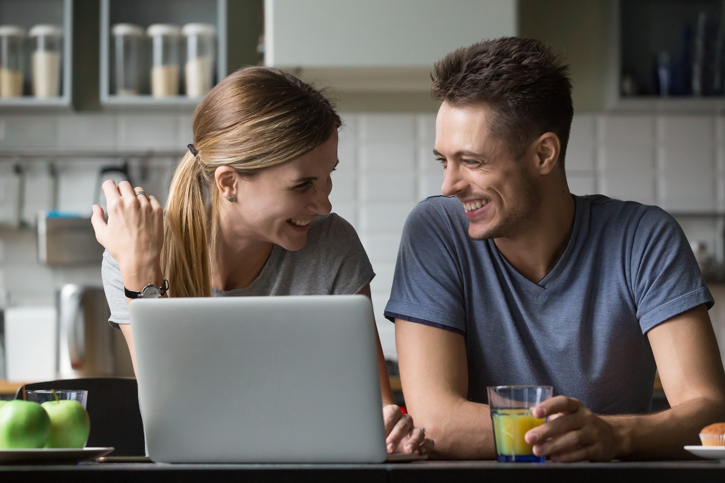 Couple are smiling each other in the kitchen 