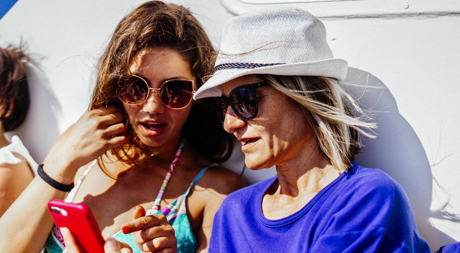 PORTRAIT OF HAPPY FRIENDS IN SUNGLASSES LOOKING AT A PHONE  (1)
