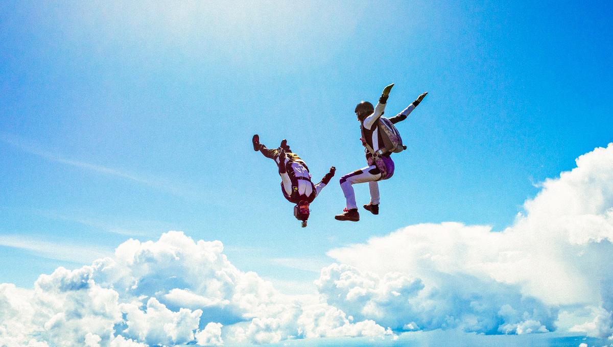 Two skydivers in freefall against blue sky