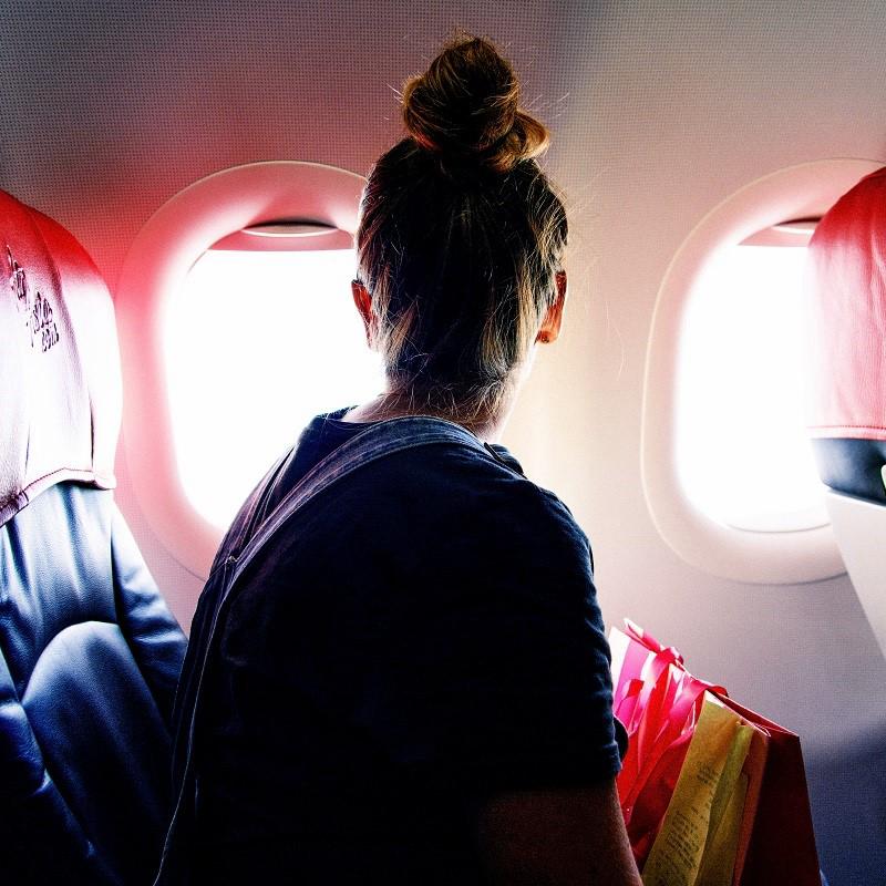 Girl watching outside airplane's window