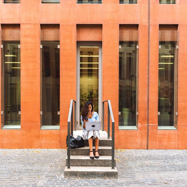 Woman checking laptop on stairs