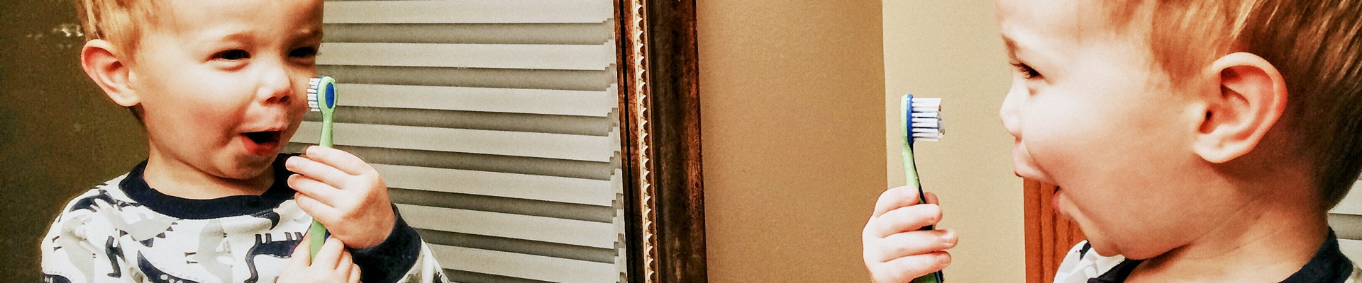 Young boy playing in bathroom with toothbrush