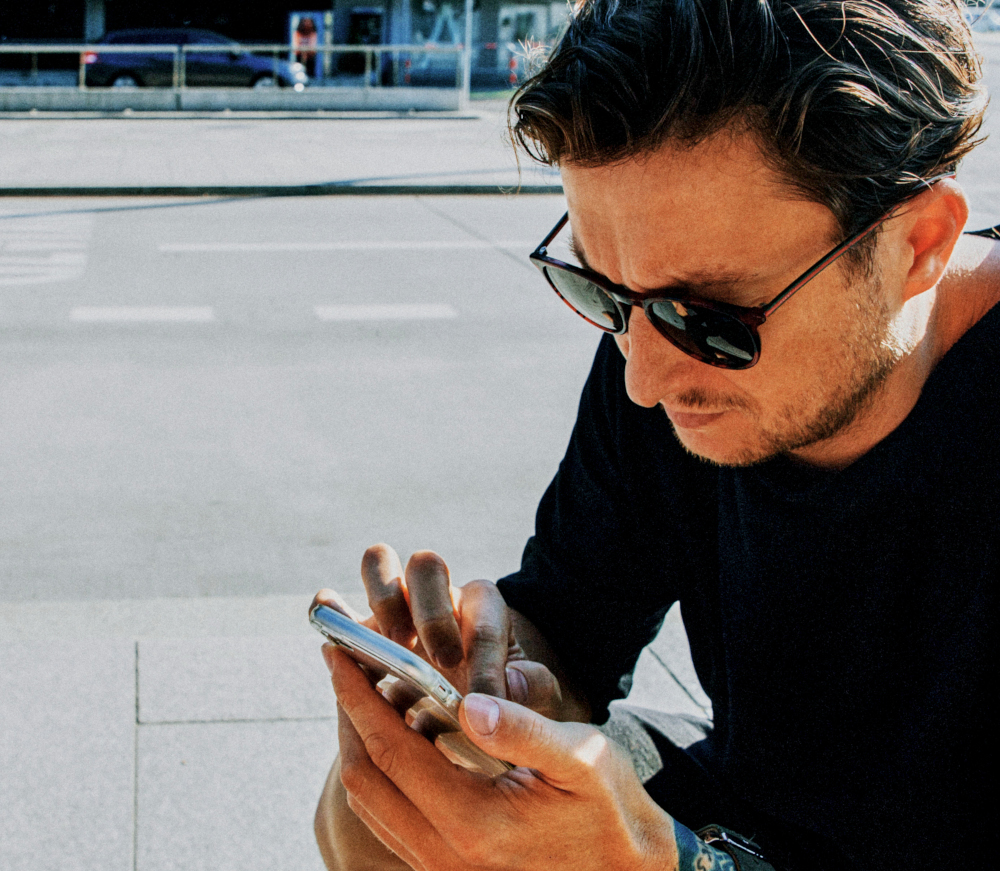 Young man using mobile phone while sitting large